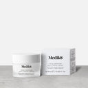 Envase y caja de la crema Total Moisture Daily Facial Cream tamaño viaje. Están apoyados en una superficie gris.