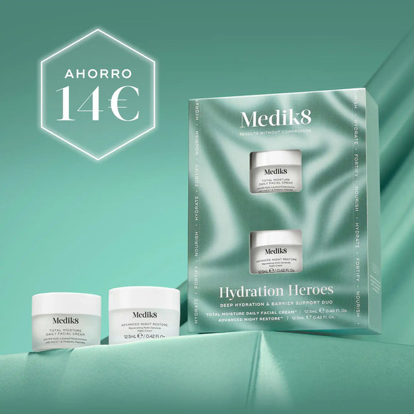 Cuatro tarros de crema Medik8 de diferentes tamaños dispuestos sobre un fondo de tela ondulado de color verde azulado oscuro. En la esquina superior izquierda se muestra de forma destacada un hexágono blanco con el texto AHORRO 14€-5