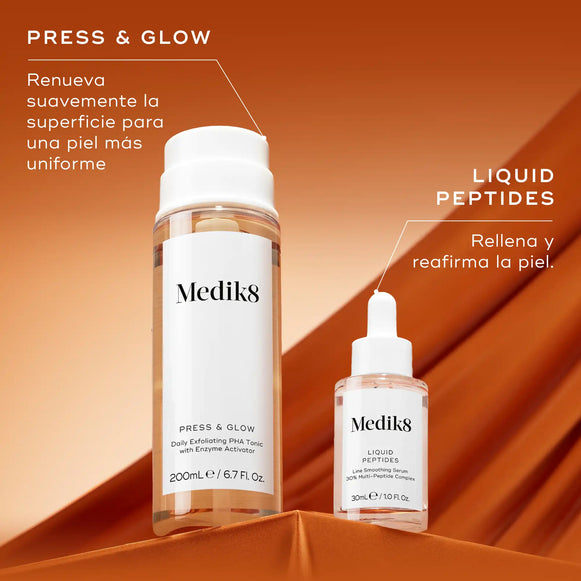Dos productos para el cuidado de la piel de Medik8, un frasco grande blanco y un frasco pequeño con cuentagotas, colocados sobre un fondo naranja intenso. El texto PRESS & GLOW aparece en la parte superior izquierda, con la descripción «Renueva suavemente para una piel más suave». Debajo de los productos, aparece LIQUID PEPTIDES, con la descripción «Rellena y reafirma la piel».-hover-6