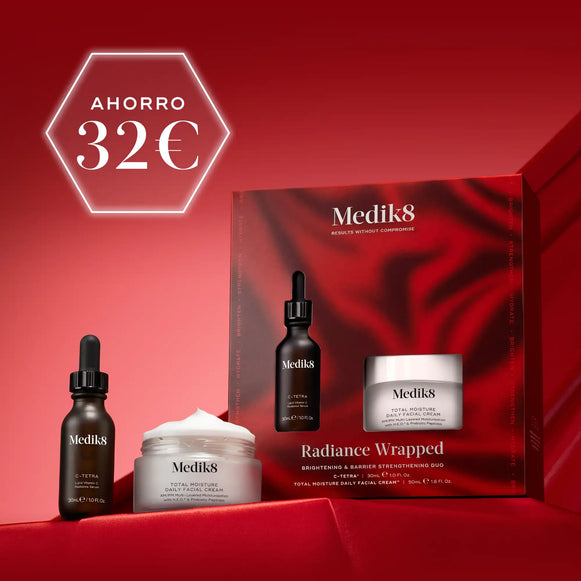 Dos productos para el cuidado de la piel de Medik8, un frasco cuentagotas oscuro y un tarro blanco, dispuestos sobre un fondo de tela ondulado de color rojo intenso. En la esquina superior izquierda se muestra de forma destacada un círculo blanco con el texto AHORRO 32€-4