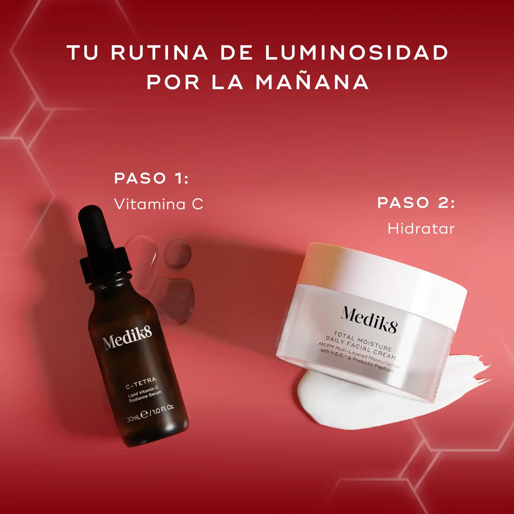 Dos productos para el cuidado de la piel de Medik8, un frasco cuentagotas oscuro (Paso 1: vitamina C) y un tarro blanco (Paso 2: hidratante), sobre un fondo rojo intenso. El texto «TU RUTINA DE LUMINOSIDAD POR LA MAÑANA» aparece en la parte superior, con «PASO 1: Vitamina C» y «PASO 2: Hidratar» claramente etiquetados junto a sus respectivos productos.