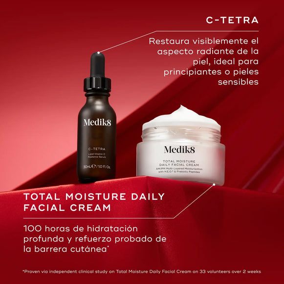 Dos productos para el cuidado de la piel de Medik8, un frasco cuentagotas oscuro y un tarro blanco, colocados sobre un fondo rojo intenso. El texto «C-TETRA» aparece en la parte superior izquierda, con la descripción «Restaura visiblemente la luminosidad de la piel». Debajo de los productos, aparece «TOTAL MOISTURE DAILY FACIAL CREAM», con «100 horas de hidratación profunda» y «Protección de la barrera cutánea» debajo.-hover-4